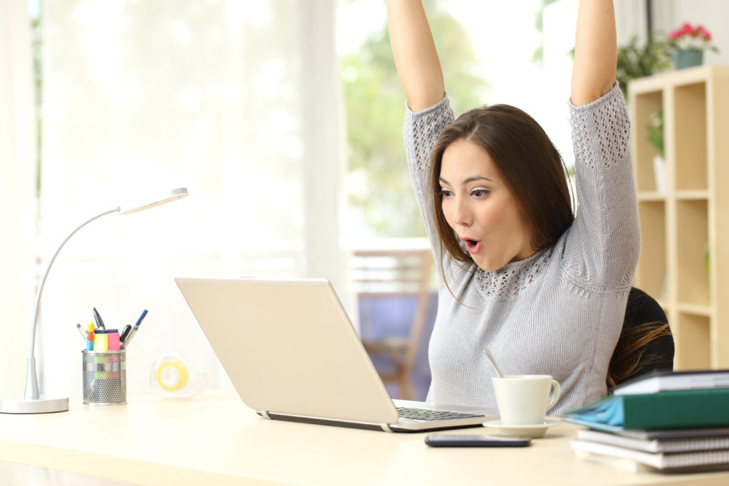 Euphoric and surprised winner winning online watching a laptop at home